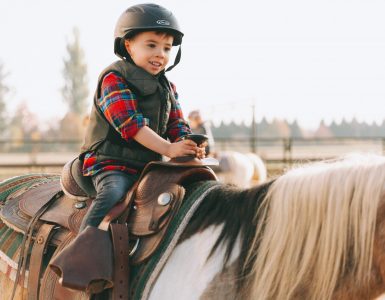 a-little-boy-riding-a-pony-TW2GJ8K
