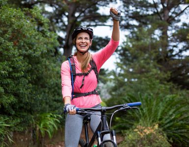 athletic-woman-standing-with-mountain-bike-VGZD4XN