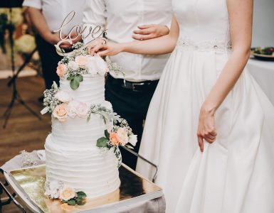 bride-and-groom-cutting-stylish-wedding-cake-at-we-JNX4EKD